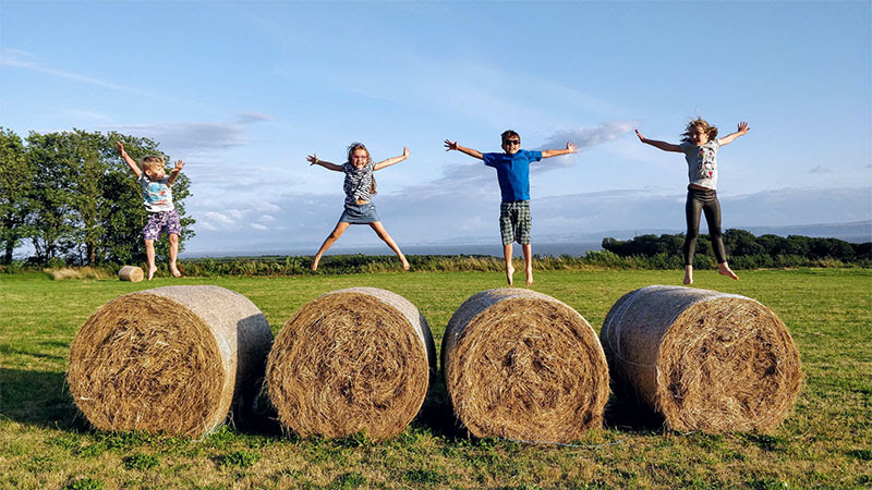 Kids jumping on hay